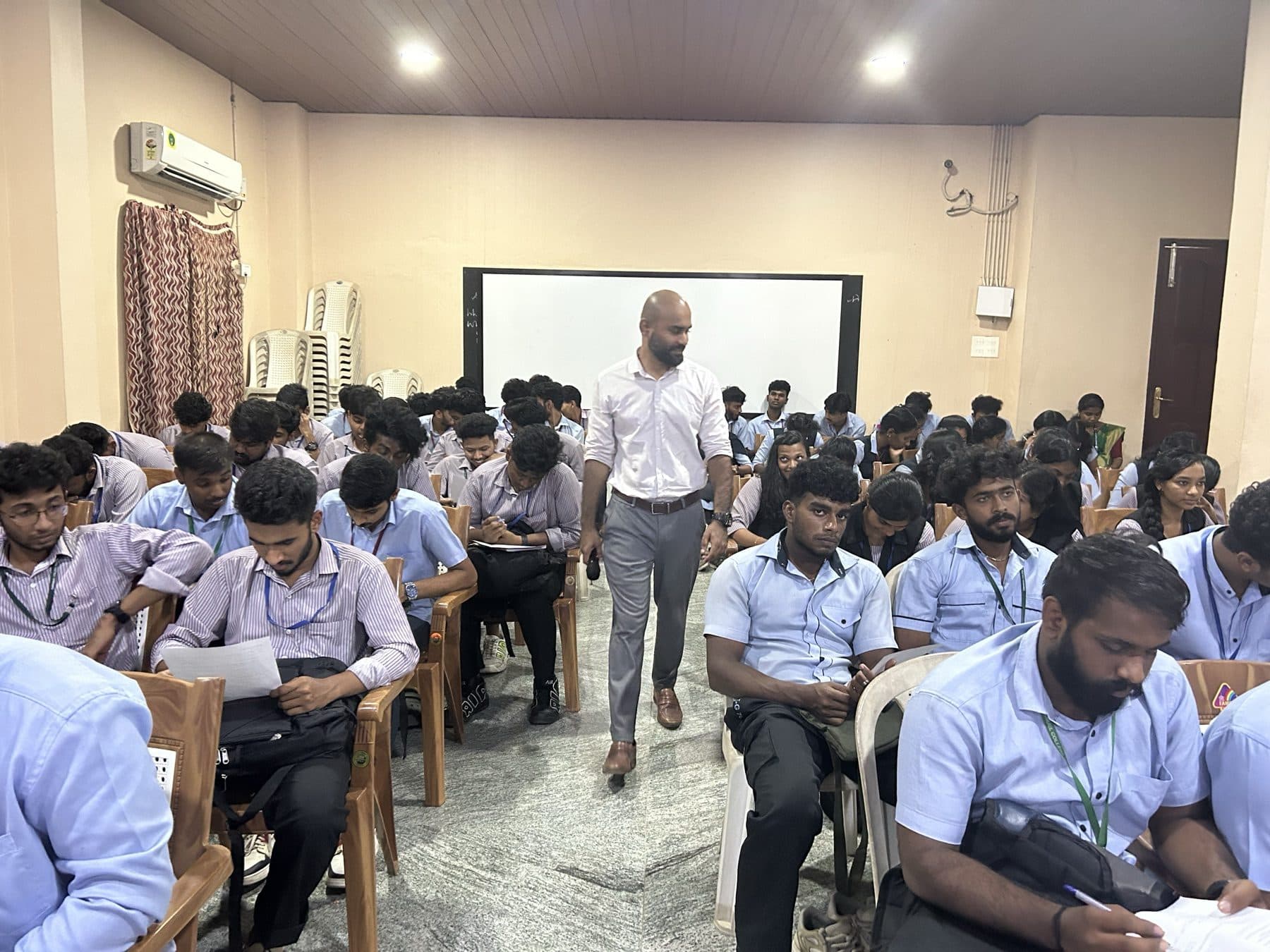 Praveen VR walking between rows of participants working on an exercise